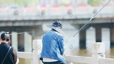 带着渔夫帽河边钓鱼的年轻人